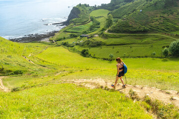 Hiker walking on sakoneta beach in zumaia, basque country, spain