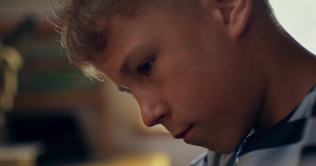 The boy controls the robot using a joystick. Close-up of his face and hands