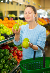 woman chooses fresh and sweet apples in farm shop