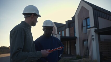 The managers of the construction company discuss the details of the construction site while standing at the facility