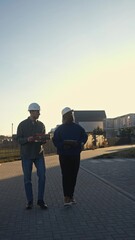 The managers of the construction company discuss the completed work as they pass by the finished houses