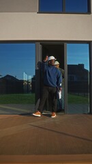 Civil engineers leave the house. They are discussing the object standing on the terrace