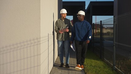 Civil engineers talk as they pass by a finished house