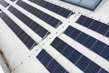 Set of solar panels on top of the concrete roof of modern building. Photovoltaic energy sources...