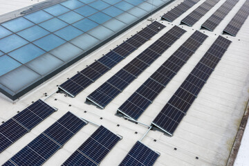 Set of solar panels on top of the concrete roof of modern building. Photovoltaic energy sources...