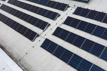 Set of solar panels on top of the concrete roof of modern building. Photovoltaic energy sources...