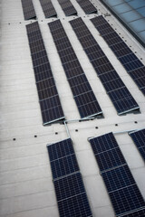 Set of solar panels on top of the concrete roof of modern building. Photovoltaic energy sources helps on increasing energy demand