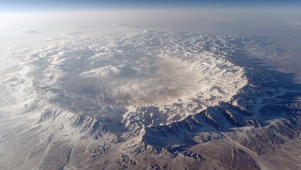 Naklejka premium High-altitude view of a ring-shaped mountain range, snow-capped peaks and a light-colored basin in the center
