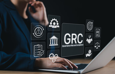 Business Concept of Governance Risk and Compliance (GRC). Businesswoman using laptop with GRC icons...