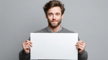 Confident Photographer in Studio Holding Blank Canvas for Creative Ideas