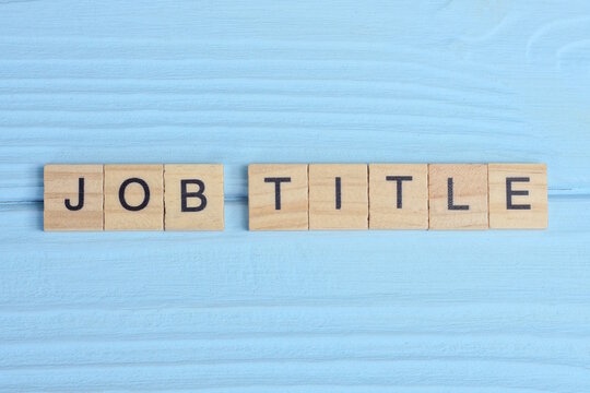 word job title made from wooden gray letters lies on a blue background
