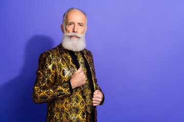Confident elderly gentleman in a stylish golden patterned jacket against a vibrant purple background