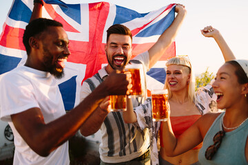 Obraz premium Friends toasting with beer celebrating with uk flag