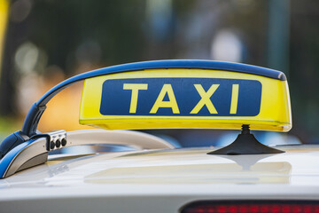 Black and yellow taxi sign on the roof of a car