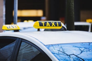 Black and yellow taxi sign on the roof of a car