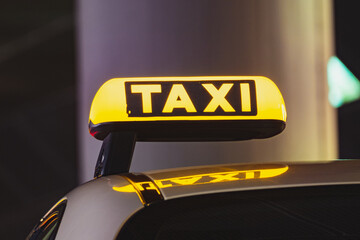 Black and yellow taxi sign on the roof of a car