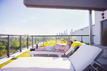 man sunbathing on roof of building, Canada, Toronto