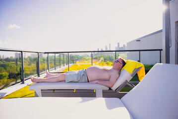 man sunbathing on roof of building, Canada, Toronto