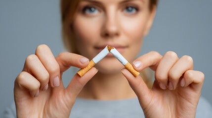 In a motivational moment, a woman holds broken cigarettes, symbolizing her decision to quit smoking. This powerful act represents a commitment to health and well-being