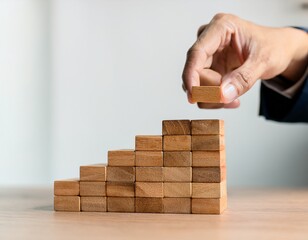 business planning strategy concept hand arranging wood block stacking as step stair