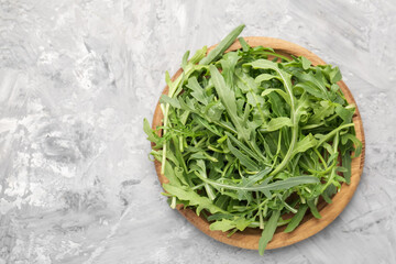 Fresh ripe green arugula leaves on grey table, top view. Space for text
