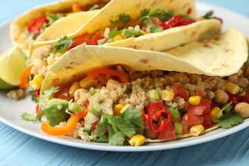 Tasty vegetarian tacos with chickpeas, corn and quinoa served on light blue wooden table, closeup
