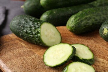 Whole and cut cucumbers on table, closeup