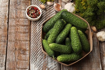 Making pickles. Fresh cucumbers and spices on wooden table, flat lay. Space for text