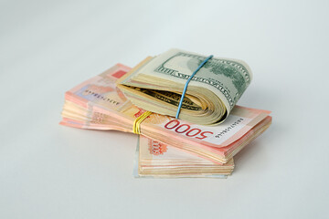 A stack of money with a green and white bill on top