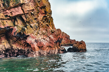 A dramatic view of the rugged coastal cliffs of the Ballestas Islands in Peru