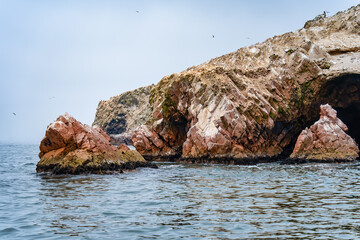 A dramatic view of the rugged coastal cliffs of the Ballestas Islands in Peru