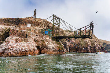 A wooden dock used for guano extraction over the rocky shore of Isla Ballesta Centro in the Ballestas Islands, Peru.