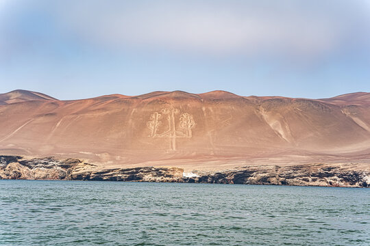 View of the ancient Candelabra geoglyph etched into the arid hillside of the Paracas Peninsula in Peru.