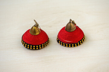 Beautiful pair of antique red Jhumka earrings for women, intricately made with silk thread,...