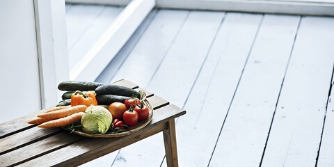 A variety of fresh vegetables including carrots, zucchini, tomatoes, and cabbage on a wooden table