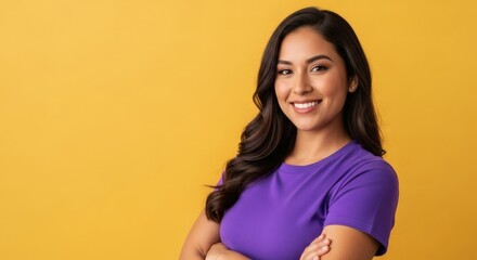 Obraz premium Smiling woman with long, dark hair in a purple shirt, against a yellow backdrop.