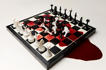 Black and white chess pieces on a chessboard with blood