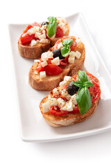 Bruschette con pomodoro fresco, mozzarella, olive, basilico e origano, spuntino italiano 
