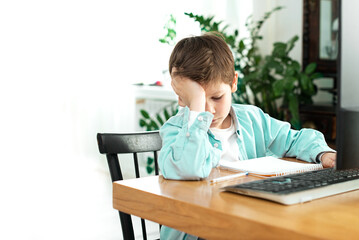 Kids and gadgets. Distance learning. Back to school. sad Boy and laptop at home.