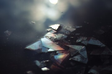 Shattered glass reflecting light in calm water at twilight creating a mesmerizing abstract display