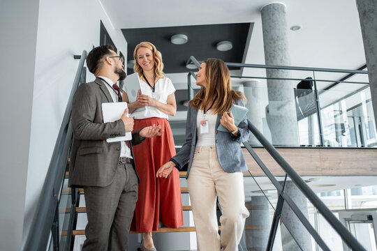 Businesspeople walking and talking on stairs in office building