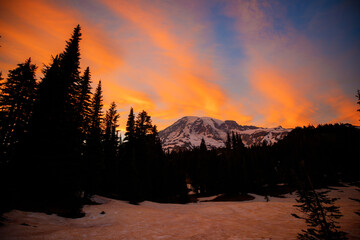 Sunset over Mount Rainier, Washington. Vibrant sky with warm hues illuminating the rugged mountain...