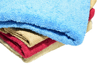 A stack of body towels of different shades lie on a white background.