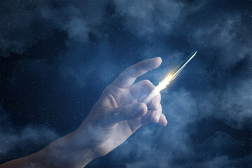 Hand launching a rocket against a starry sky