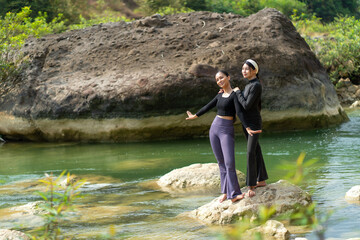 Asian Indonesian Women Practicing Yoga and Wellness by a River in Nature