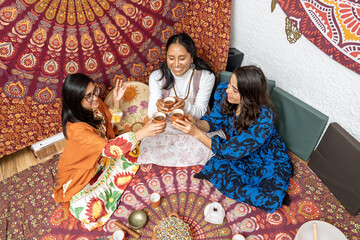 Women holding cocoa ceremony with singing bowls and mandala tapestry