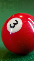 Macro shot of the number detail on a glossy 3 ball, ultra detailed surface texture and reflection of the pool table lights, high-definition realism