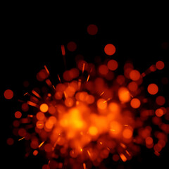 Background of feint blurred orange sparks from fire against black with copyspace