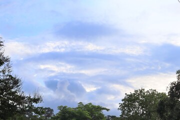 Fototapeta premium Celestial Canvas: a stunning natural scene, where fluffy, cotton-candy clouds drift across the azure expanse, offering a serene and breathtaking vista.
