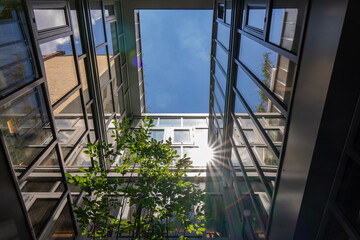 Vue intérieure d’un patio entièrement fermé par des façades vitrées, laissant apparaître le...